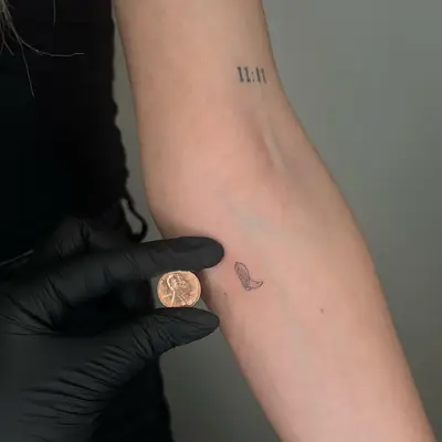 A tiny tattoo of a cowboy boot on the arm