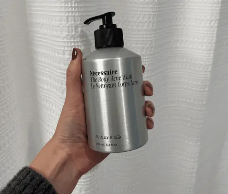 Person dispenses Kosas Good Body Skin AHA + Enzyme Exfoliating Body Wash into their hand next to a hand with Neutrogena body clear body wash