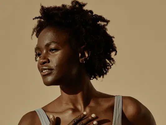 model with coily hair staring off into the distance