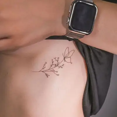 image of black ink fine line tattoo of butterfly on top of plant