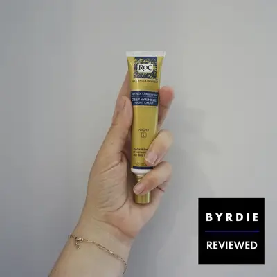 Hand holding a tube of RoC Retinol Correxion Deep Wrinkle Night Cream