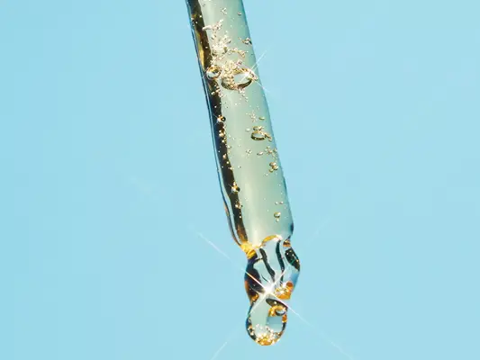 Dropper with hydrating serum on blue background