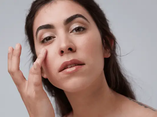 Close up of woman touching her under eye