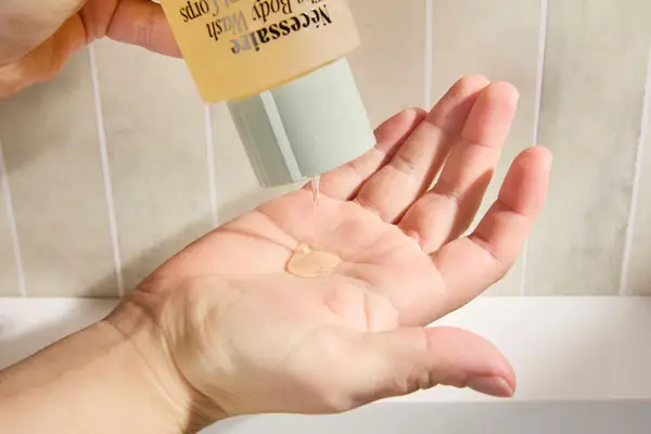 Person dispenses Nécessaire The Body Wash into their hand
