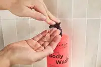 Person dispenses frank body Everyday Clearing Body Wash into their hand