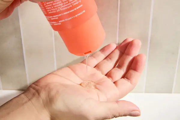 Person dispenses Kosas Good Body Skin AHA + Enzyme Exfoliating Body Wash into their hand