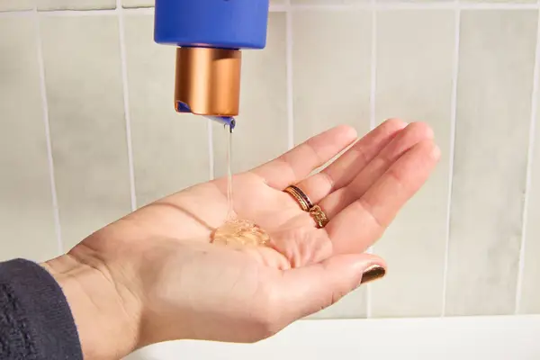 Person dispenses Augustinus Bader The Body Cleanser into their hand