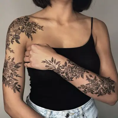 A model with rose and daisy bushel tattoos on their arms.