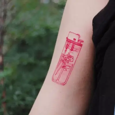 Rose lighter tattoo on arm.