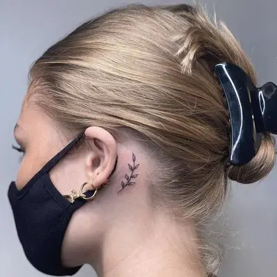 tree branch behind the ear tattoo