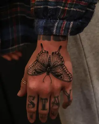 Close up of butterfly tattoo on the back of the hand