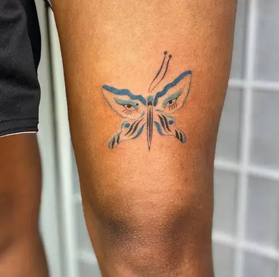 Close up of tattoo above the knee with eye design