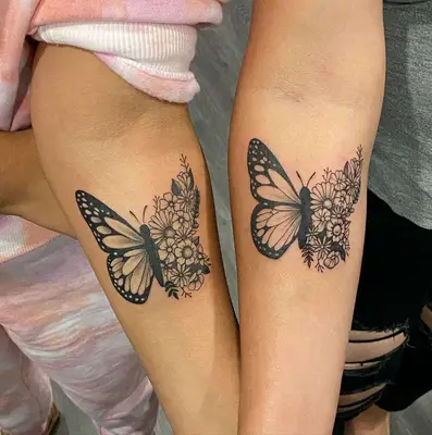 Matching butterfly tattoos on two arms