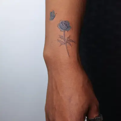 Blue butterfly and rose wrist tattoo