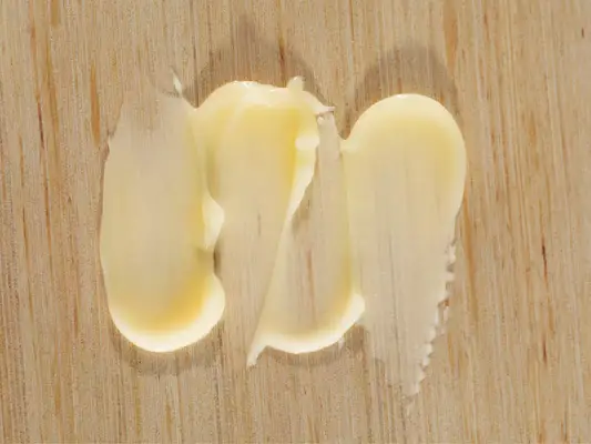 swatches of collagen cream against a wood surface