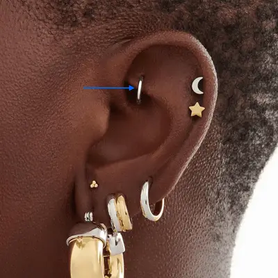 close up of silver rook hoop piercing in woman