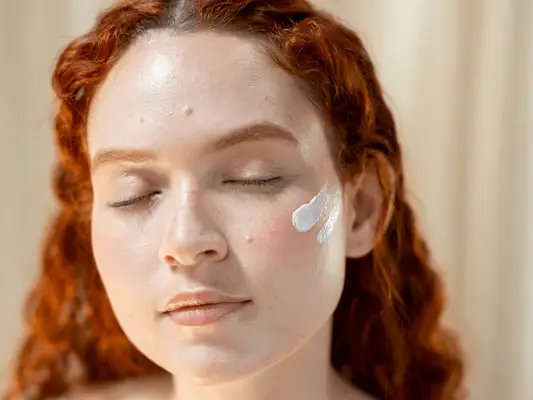 Red-hair Woman with product on face skin