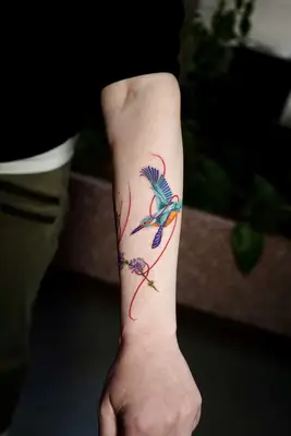 two blue birds tattooed on an arm