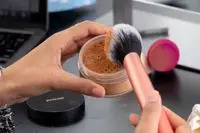 brush with the Mented Cosmetics Skin Silk Loose Setting Powder on it 