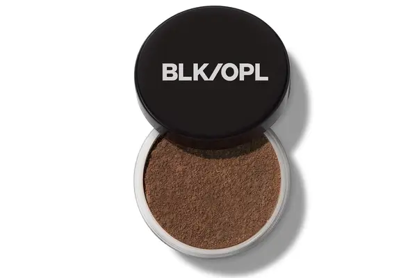 woman applying e.l.f. Cosmetics Halo Glow Setting Powder in front of mirror