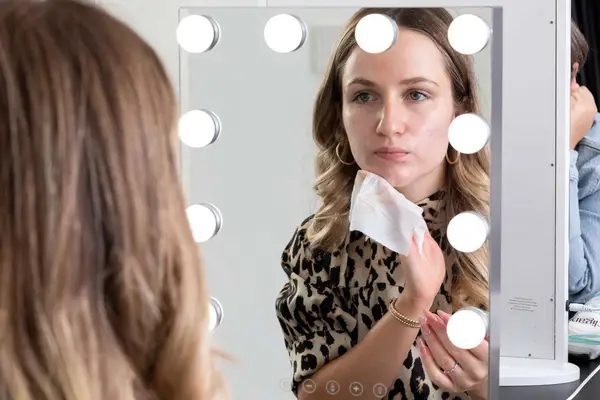 woman cleaning off face after using the Maybelline Fit Me Loose Finishing Powder