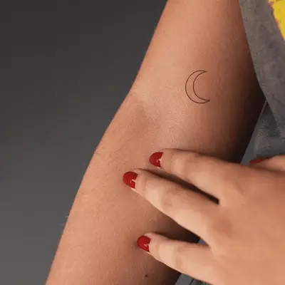Crescent moon upper arm tattoo