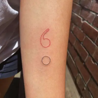 Arm with thin red and black outline semicolon tattoo