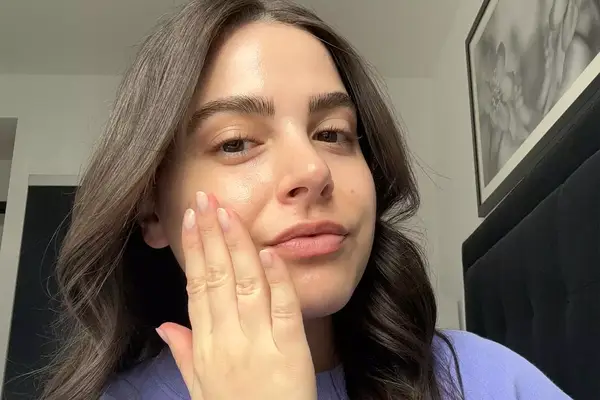 a photo of a woman testing the Prequel Half & Half Fluid Moisturizer on her face