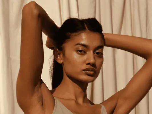 Close up of woman with her arms up showing underarms