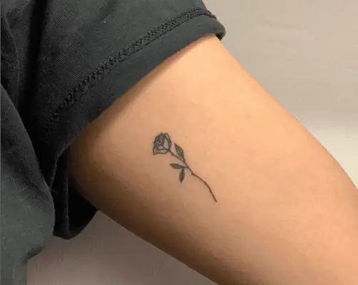 woman with rose tattoo on inside of arm