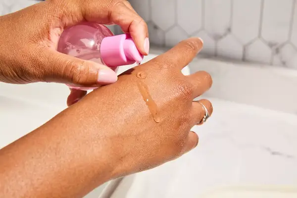 Person dispenses Glow Recipe Plum Plump Hyaluronic Acid Serum on their hand
