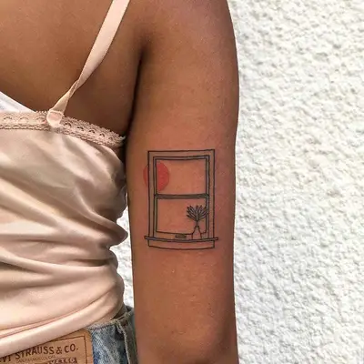 Back of arm with window tattoo with orange sun symbol