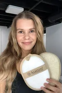 A person holds up the Almooni Natural Loofah Exfoliating Body Scrubber