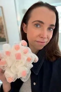 A person holds up the ecoTools Lathering EcoPouf Bath Sponge