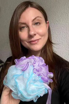 A person holds up the SHOWER BOUQUET Loofah-Bath-Sponge