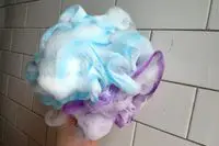 A person lathers soap in the SHOWER BOUQUET Loofah-Bath-Sponge