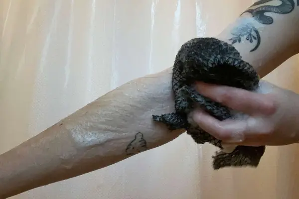 image of a person using LuvScrub Mesh Body Exfoliator on their arm