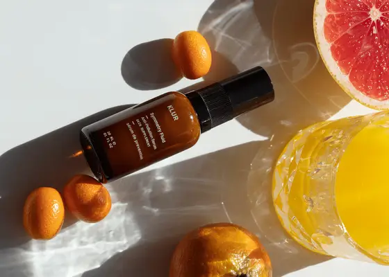 Skincare product bottle with citrus fruits and juice