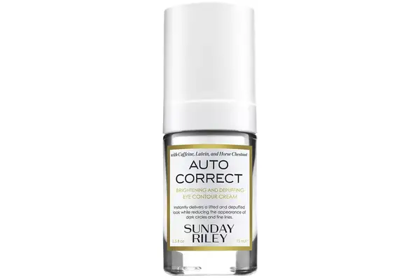 Closeup of hand applying anti-aging eye tightening serum under person’s eye while looking into mirror