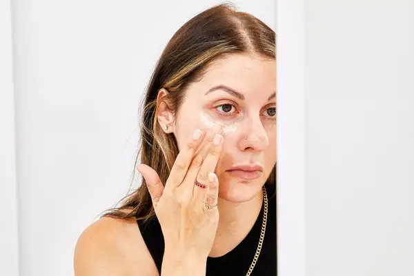 Person applying ILIA Bright Start Retinol Alternative Brightening Eye Cream