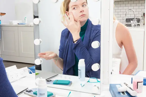 Reflection in mirror of person applying Paula