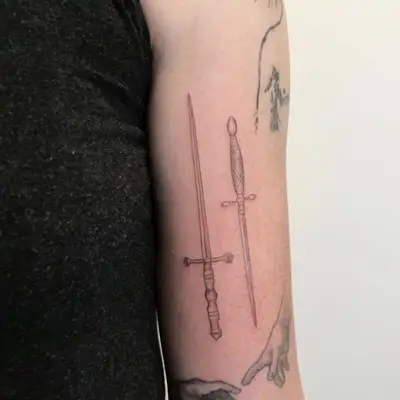 Double sword tattoo on arm