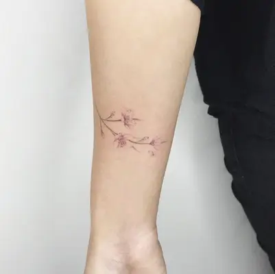 Colorful cherry blossom tattoo on forearm