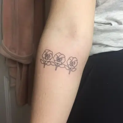 Tattoo of three pansies on forearm