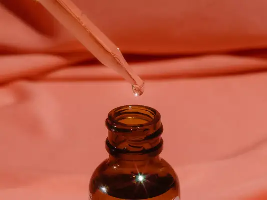 exfoliating serum dropper against orange background