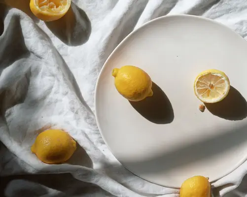 Lemons on a cream-colored plate and ivory cloth