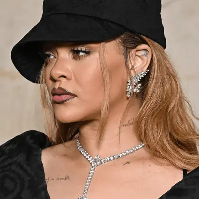 Rihanna on a red carpet with a star ear tattoo