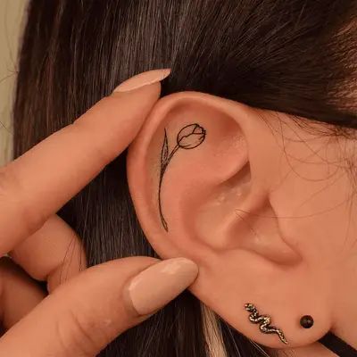 A rose tattoo on the inner ear lobe
