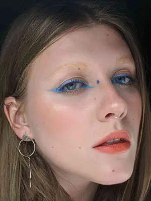 close-up of woman with bridge piercing and blue eyeliner