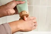 Person dispenses Biossance Squalane + Enzyme Sugar Body Scrub on their hand
